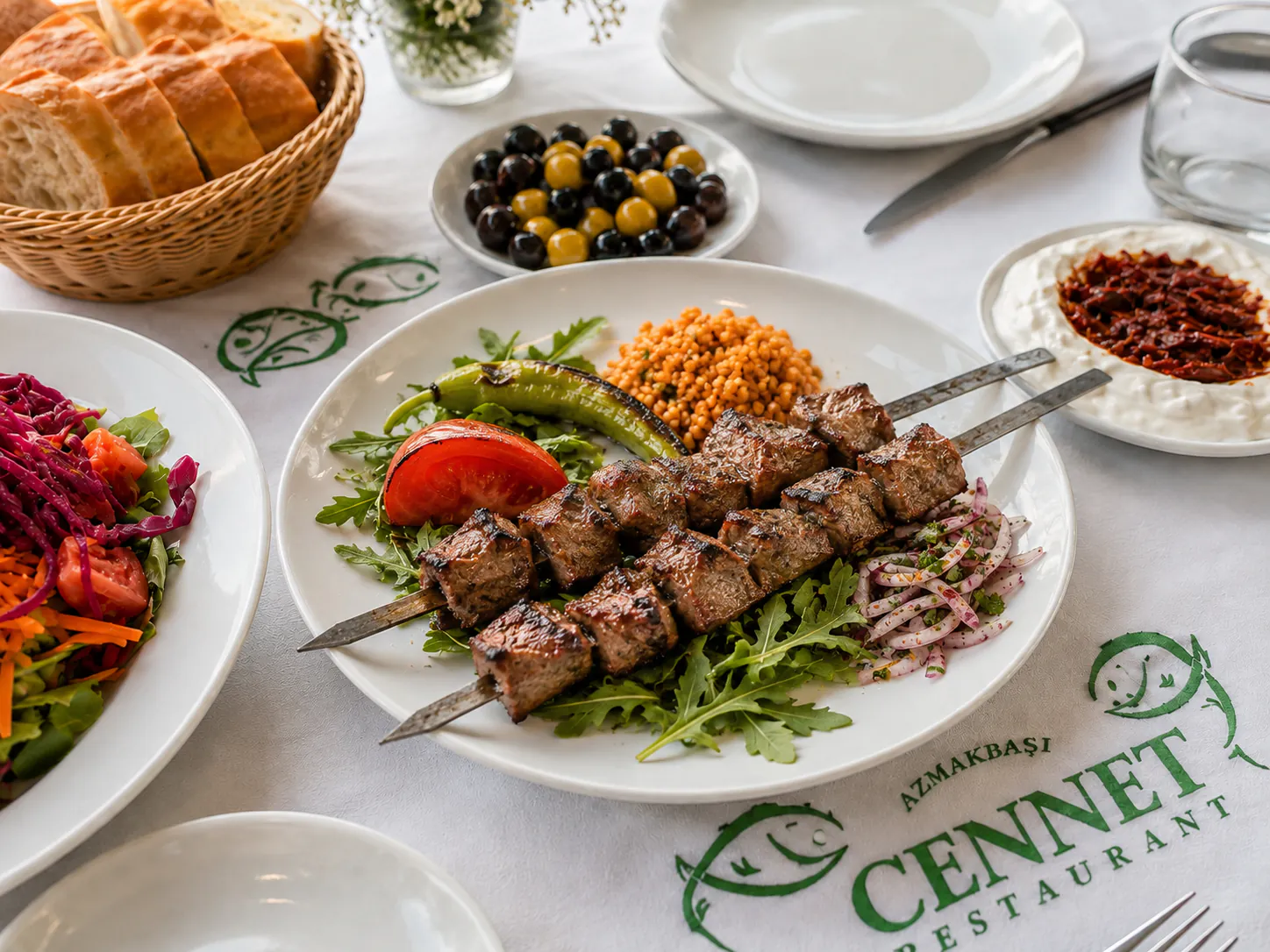 Közde pişmiş kuzu şiş, pilav ve mevsim yeşillikleriyle Cennet Restaurant sofrasında
